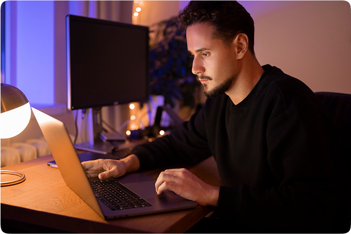 Nikolay Sogdianov working on laptop in ambient lighting