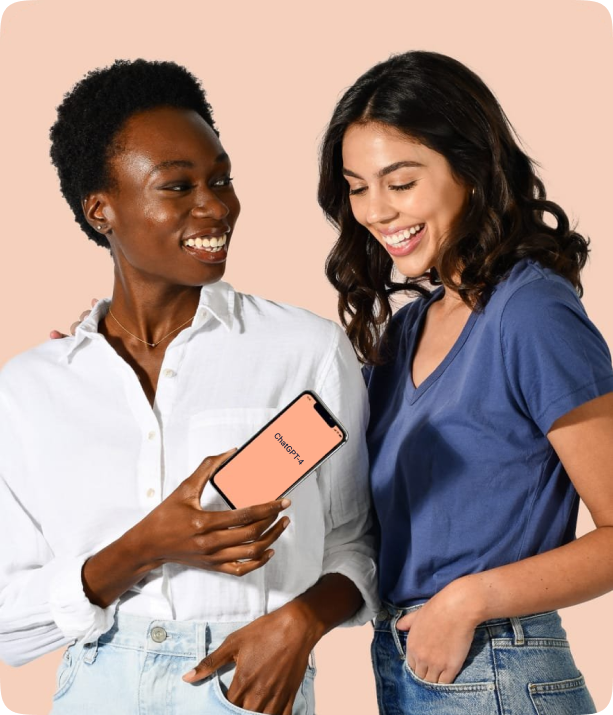 Two women looking at a mobile device together, smiling